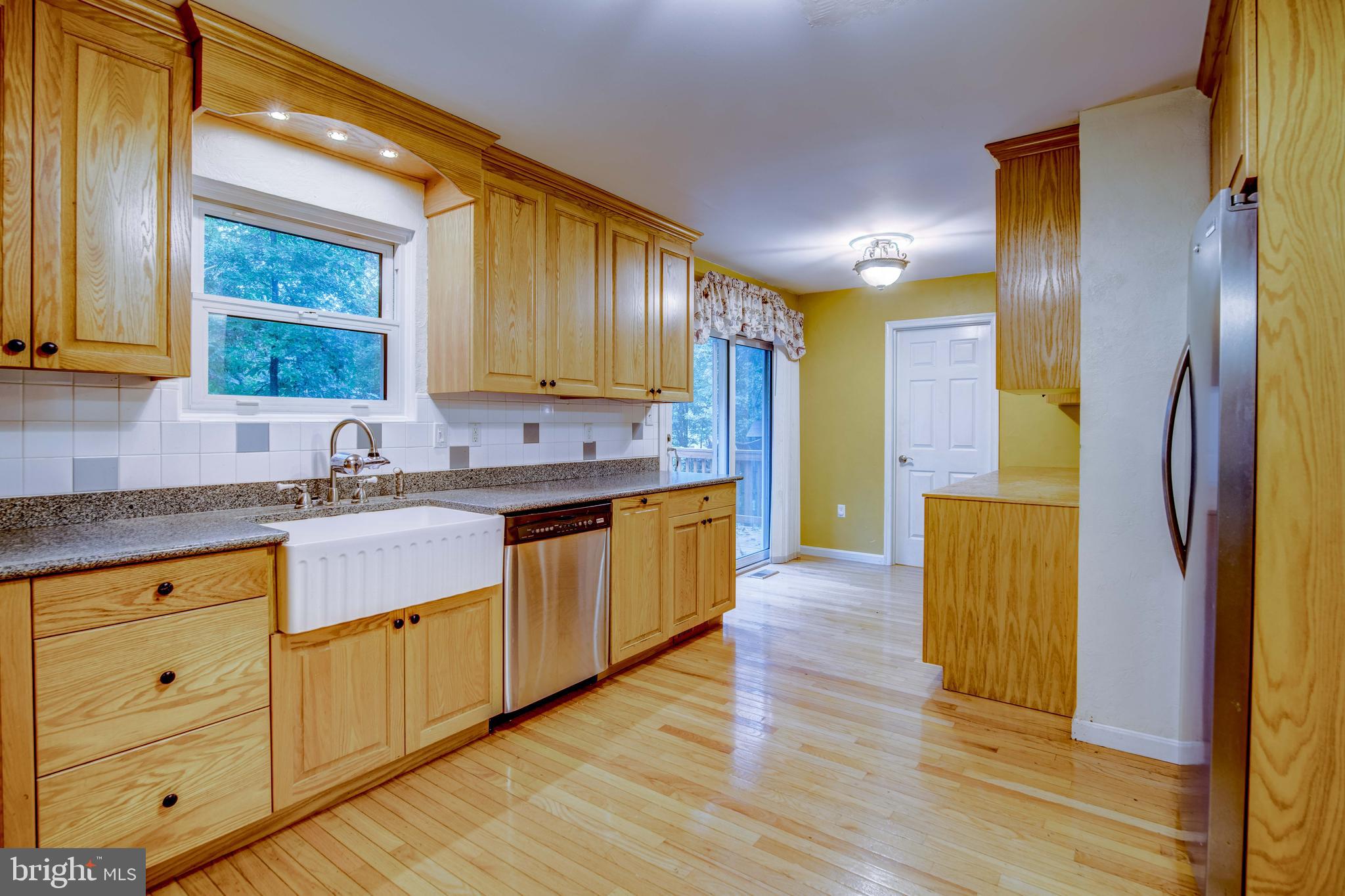 11431 Rawhide Road Lusby, MD 20657 - Photo 7 of 31 a kitchen with wooden floors cabinets and stainless steel appliances