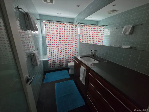 a bathroom with a tub sink and mirror