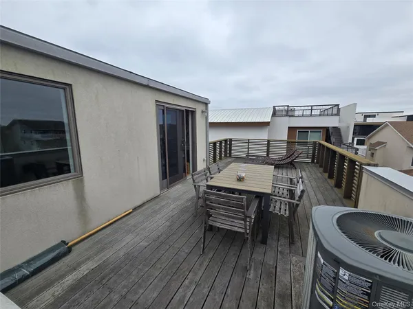 a view of a roof deck with wooden floor and outdoor seating