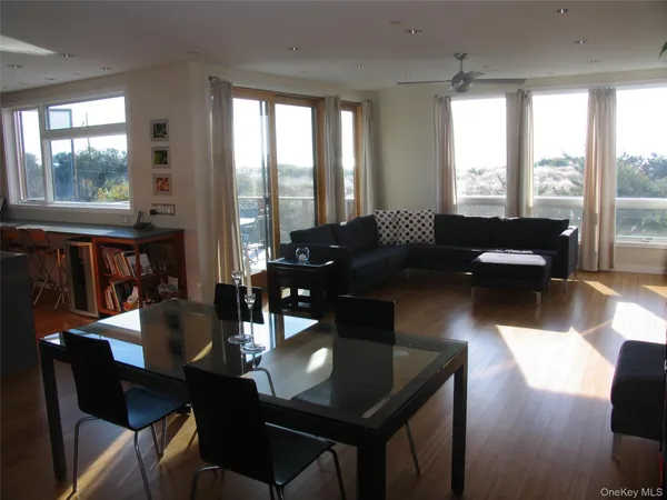 a living room with stainless steel appliances lots of furniture and a window