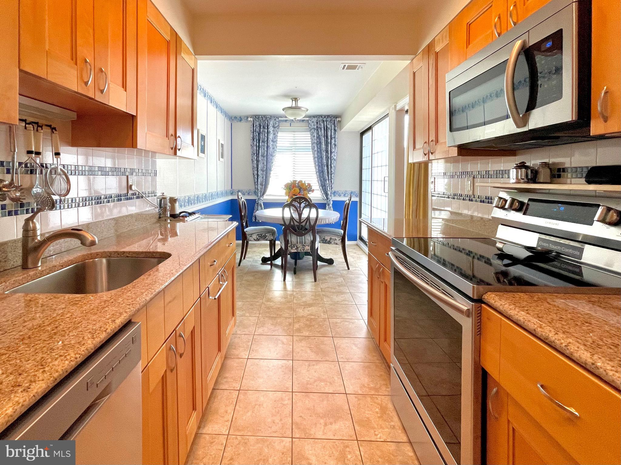 a kitchen with stainless steel appliances granite countertop a sink dishwasher stove top oven and cabinets