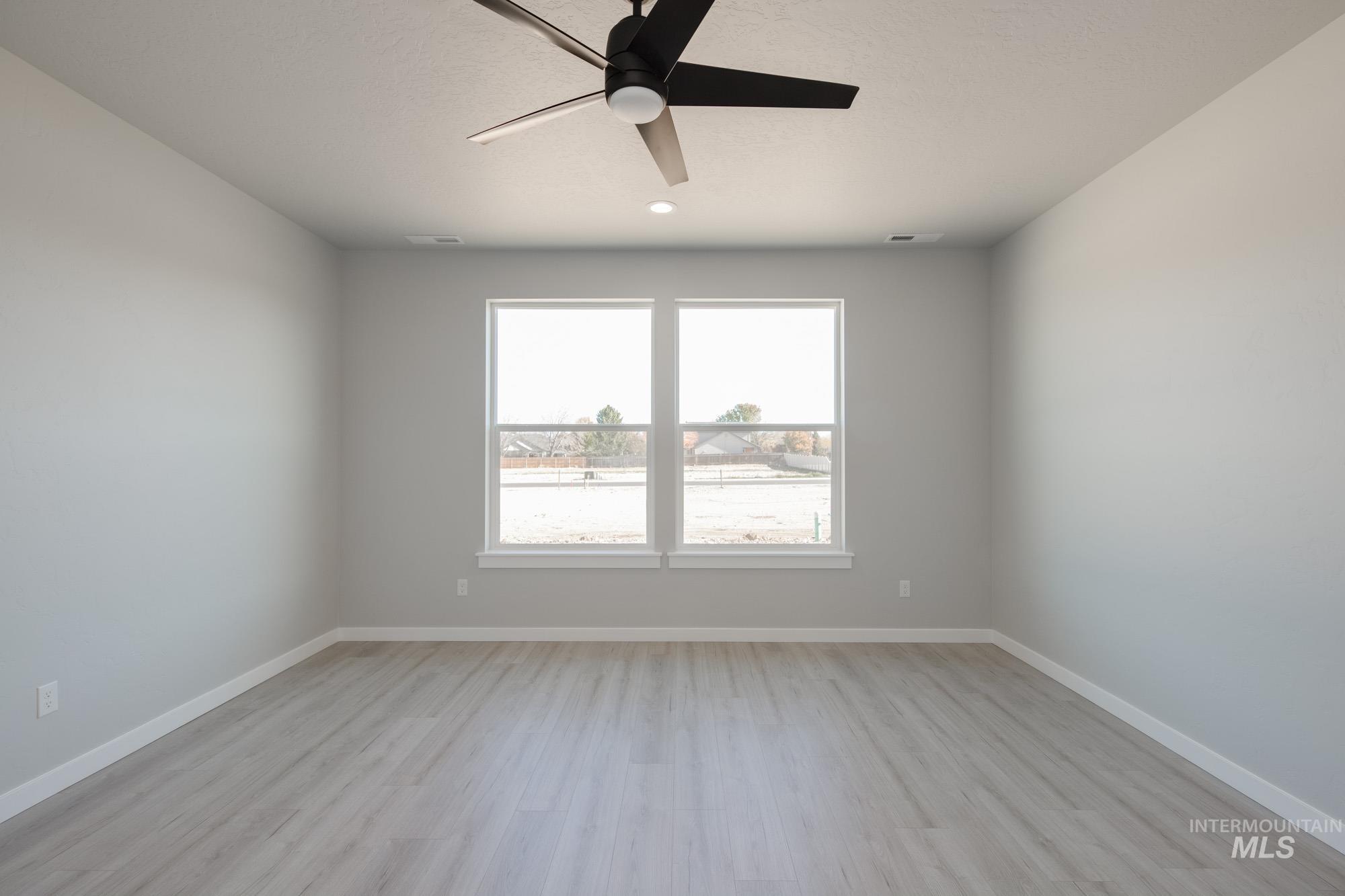 2168 South Border Way Meridian, ID 83642 - Photo 11 of 25 Empty room with a ceiling fan and light wood finished floors