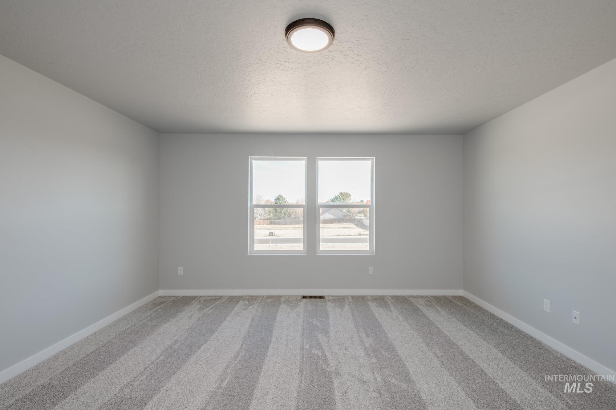 2168 South Border Way Meridian, ID 83642 - Photo 14 of 25 Empty room with light carpet and a textured ceiling