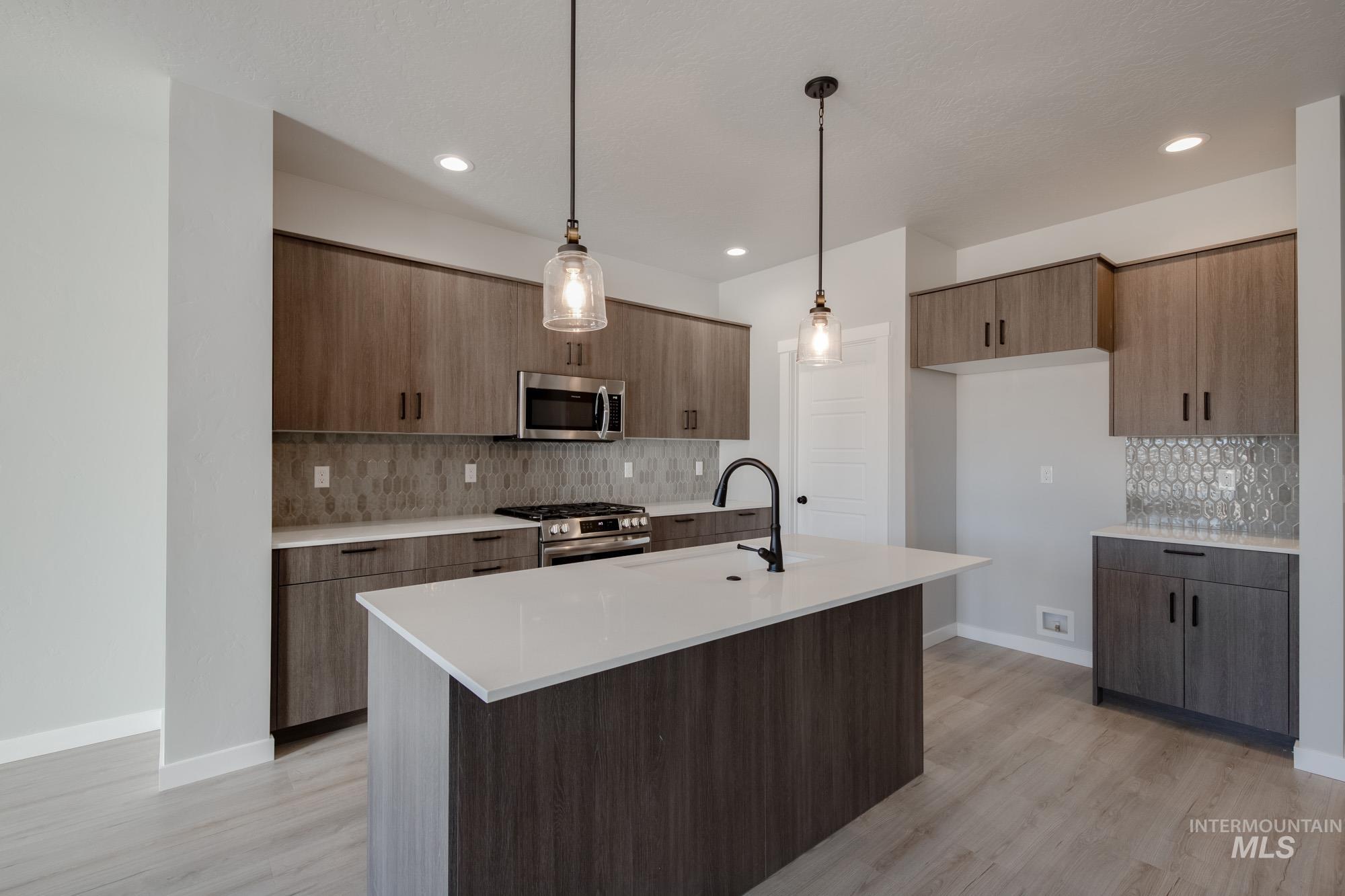 2168 South Border Way Meridian, ID 83642 - Photo 4 of 25 Kitchen featuring decorative light fixtures, stainless steel appliances, modern cabinets, and light stone countertops