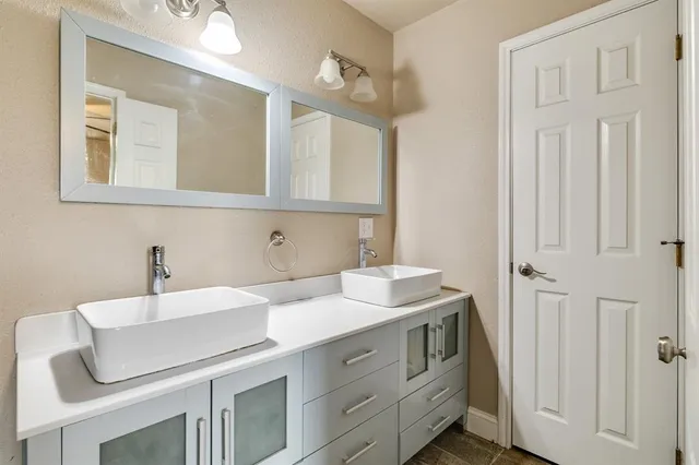 a bathroom with double sink and a mirror