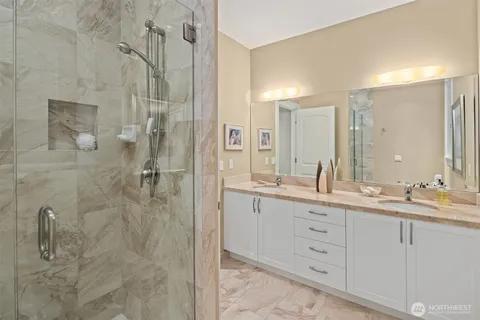a bathroom with a double vanity sink mirror and shower