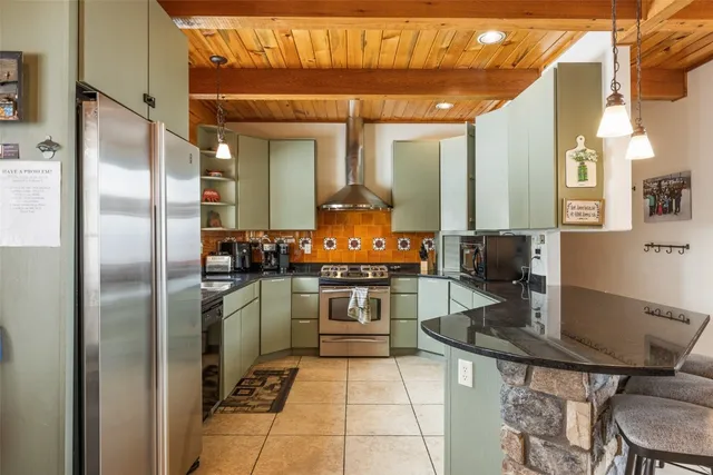 a kitchen with stainless steel appliances granite countertop a stove and a refrigerator