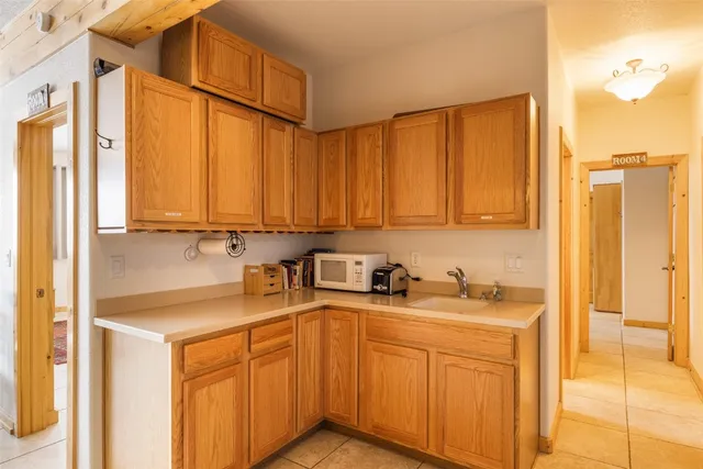 a utility room with stainless steel appliances a sink cabinets and a window