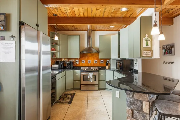 a kitchen with stainless steel appliances granite countertop a stove a sink and a microwave