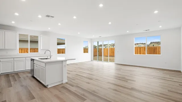 a large kitchen with stainless steel appliances granite countertop a stove and a wooden floors