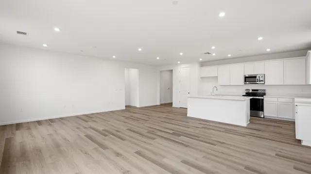 a view of kitchen with granite countertop cabinets and refrigerator