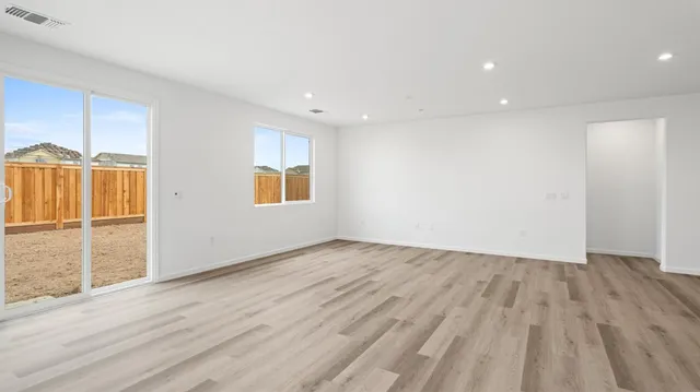 an empty room with wooden floor and a window