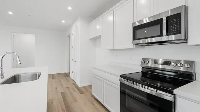 a kitchen with stainless steel appliances a sink a stove and microwave