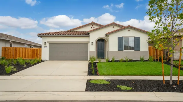 a front view of a house with a garden