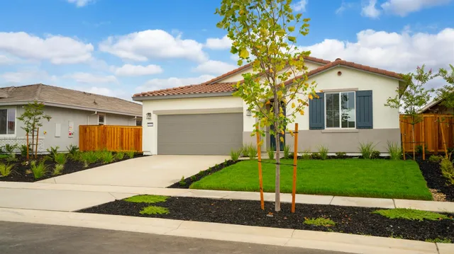 a front view of a house with a garden and yard