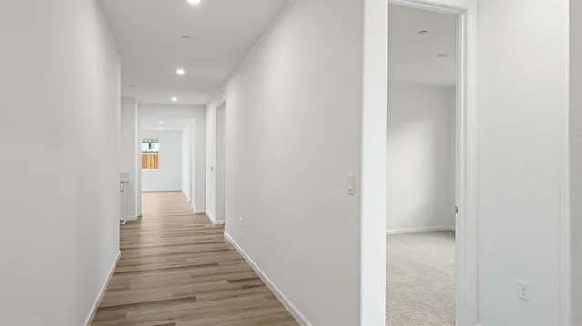 a view of a hallway with wooden floor