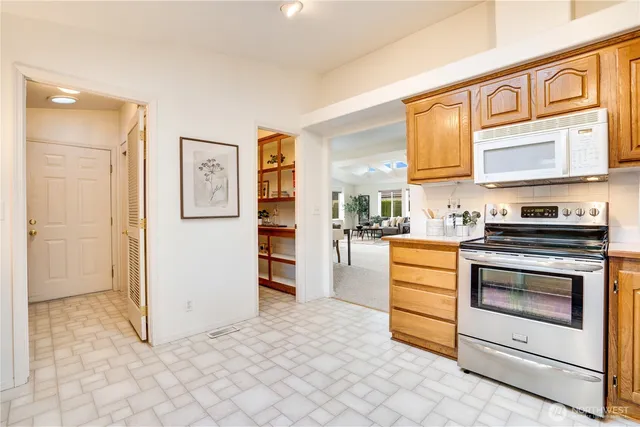 a kitchen with stainless steel appliances cabinets and a window