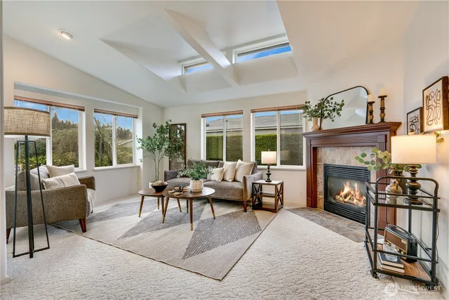 a living room with furniture a fireplace and a floor to ceiling window