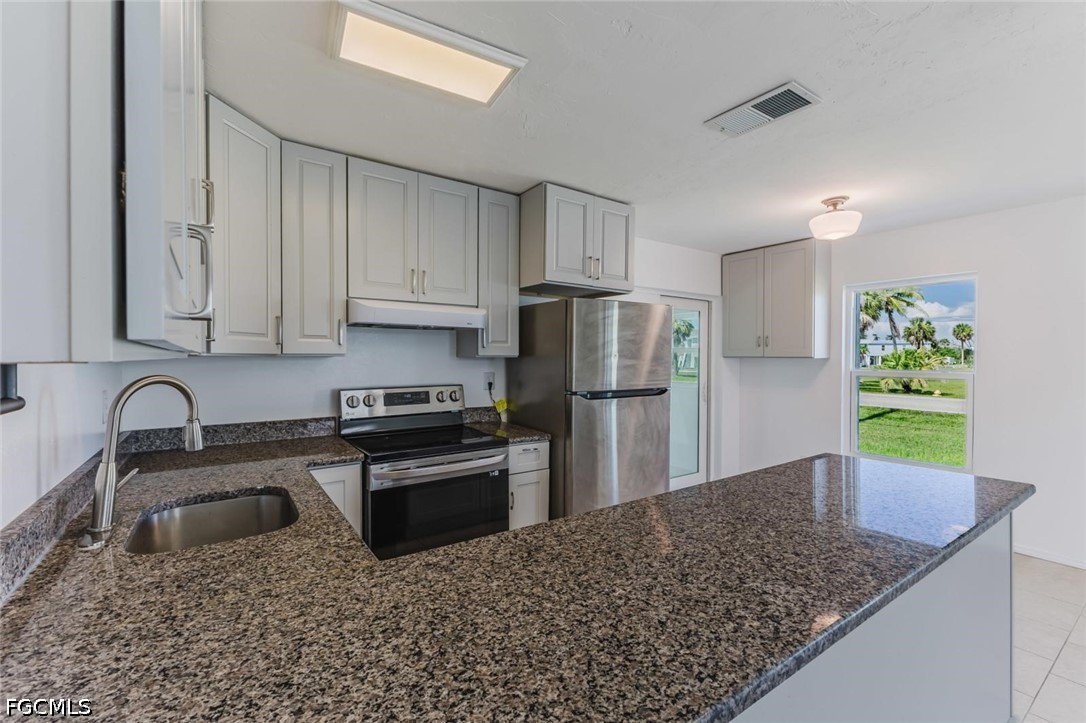 16595 Davis Road Fort Myers, FL 33908 - Photo 12 of 31 a kitchen with stainless steel appliances granite countertop a sink stove and refrigerator