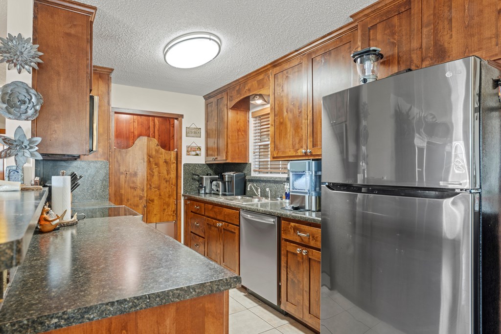 3417 Kc 443 Harper, TX 78631 - Photo 40 of 65 a kitchen with stainless steel appliances granite countertop a refrigerator a stove and a sink with wooden floor