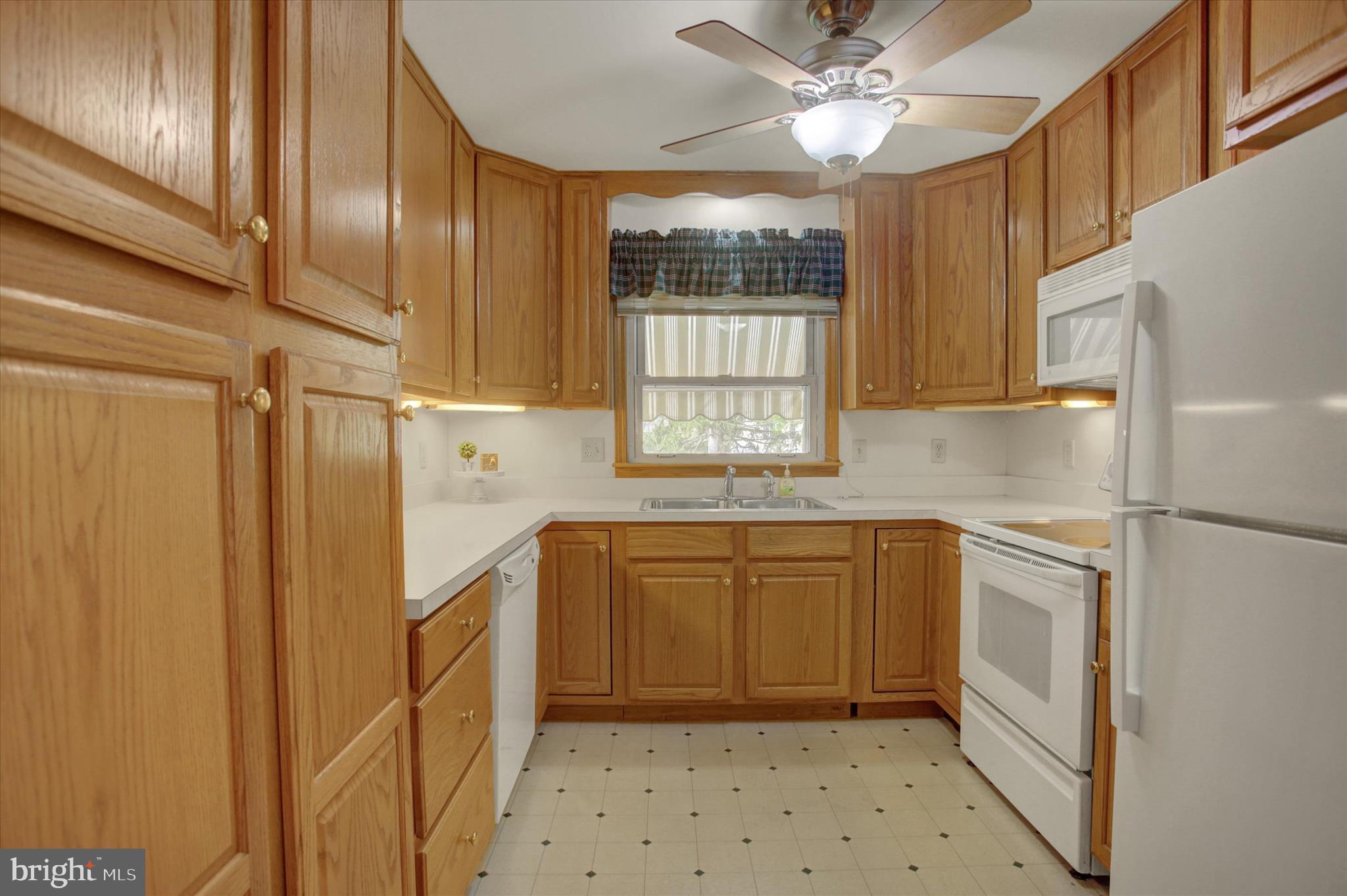 18514 Indian Cottage Road Hagerstown, MD 21742 - Photo 26 of 56 a kitchen with a refrigerator a sink and dishwasher a oven with white cabinets