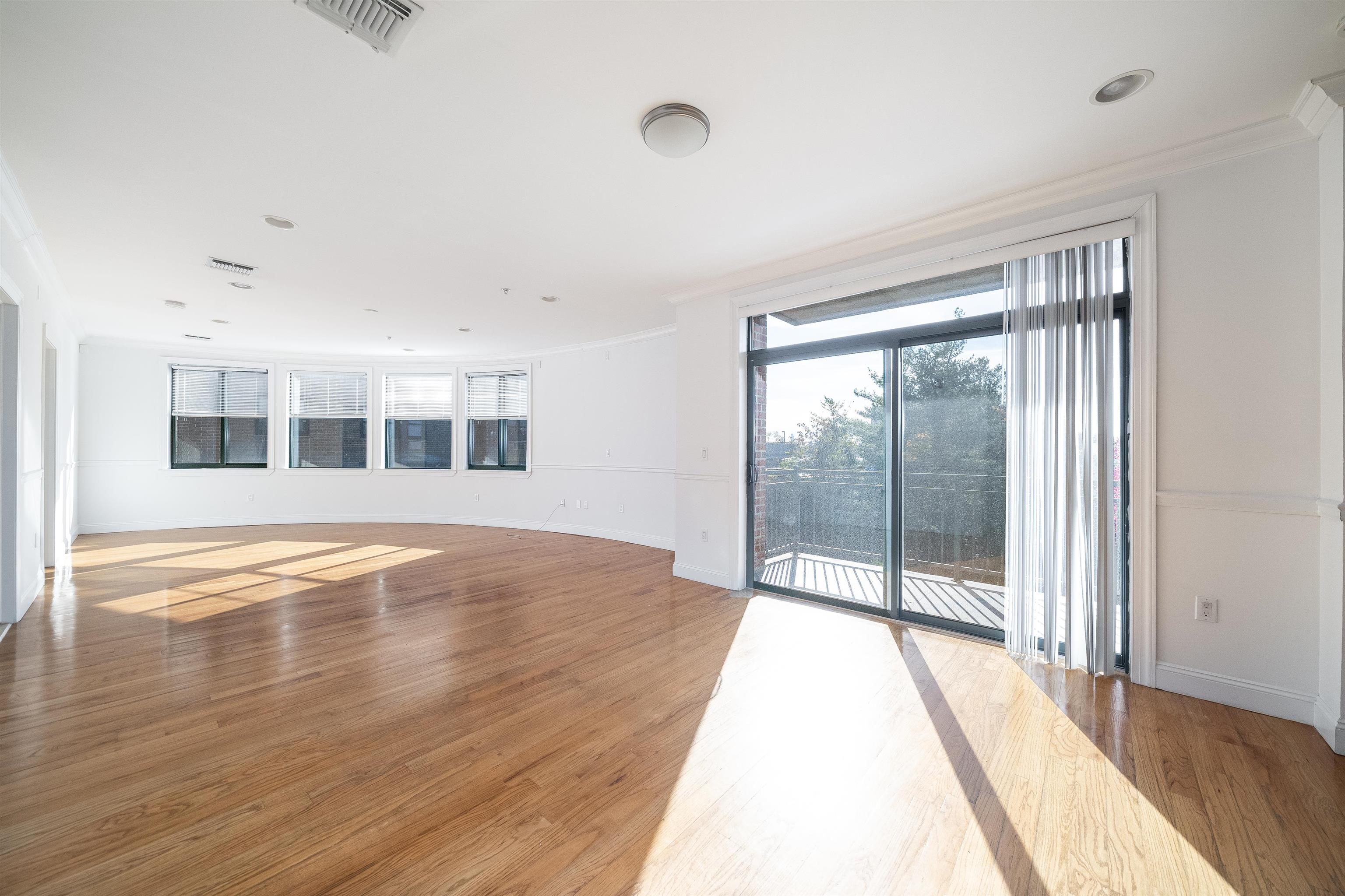 85 Maple Street, Unit 3K Weehawken, NJ 07086 - Photo 2 of 14 a view of an empty room with wooden floor and a window
