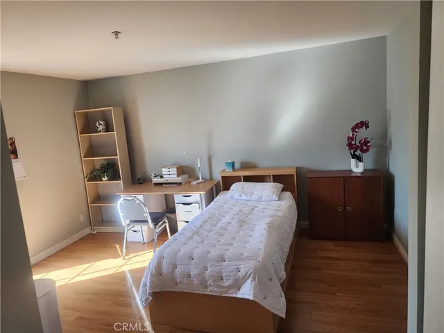 a bedroom with a bed and a refrigerator