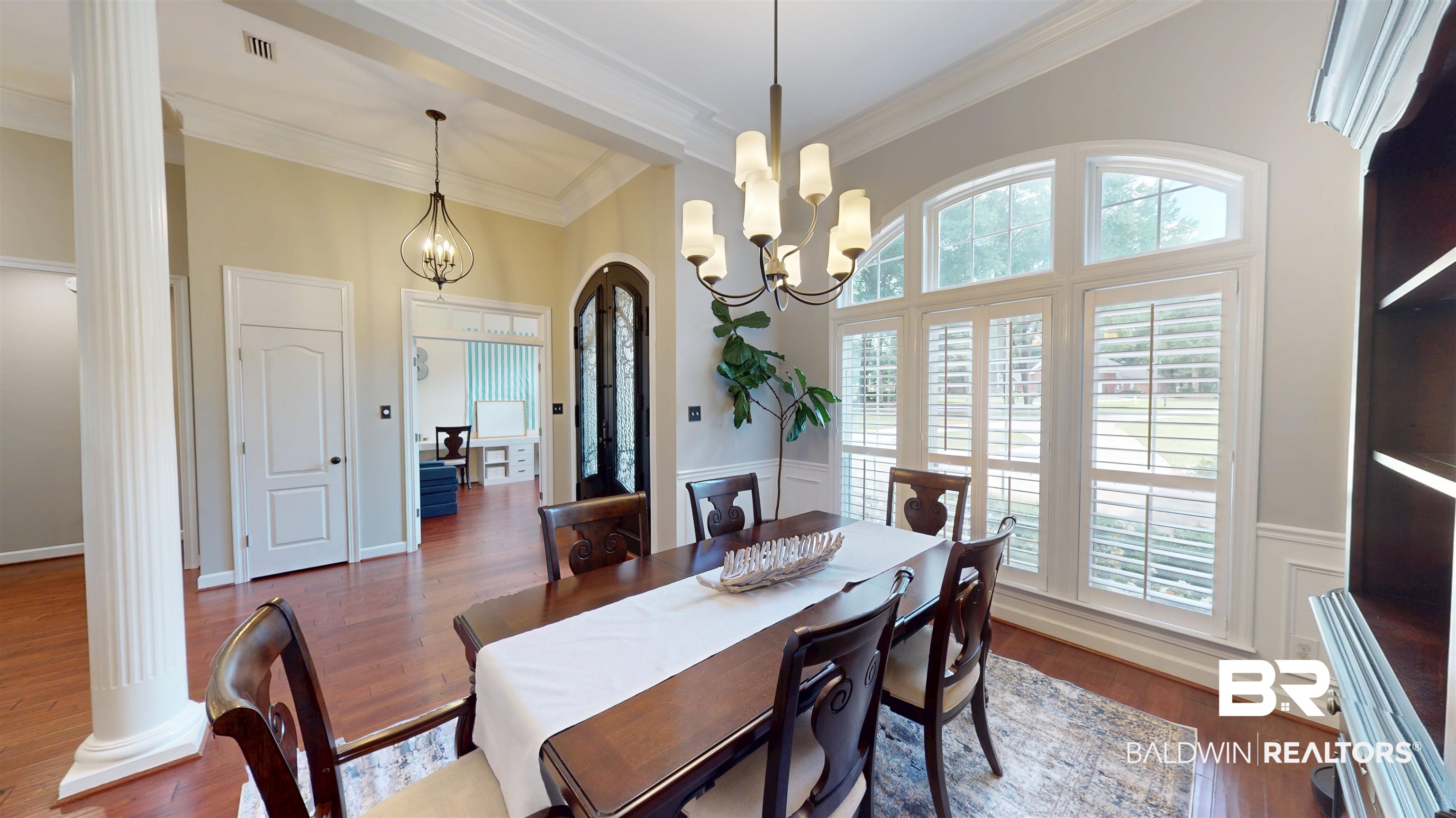 8775 Dawes Lake Road North Mobile, AL 36619 - Photo 14 of 59 Dining space with ornate columns, ornamental molding, dark wood-style floors, a wainscoted wall, and a decorative wall