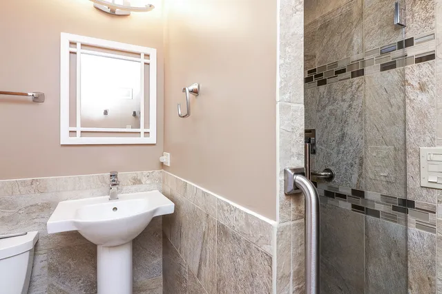 a bathroom with a sink a toilet and shower