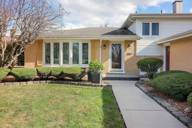 a front view of a house with a yard and outdoor seating