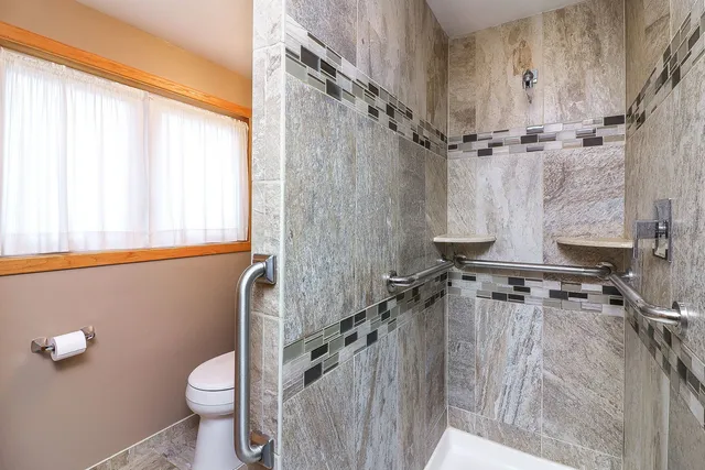 a bathroom with a toilet a sink and shower