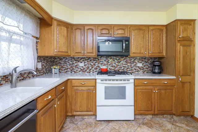 a kitchen with stainless steel appliances granite countertop a sink stove and microwave