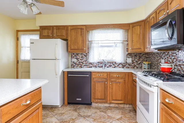 a kitchen with stainless steel appliances granite countertop a refrigerator sink stove and microwave