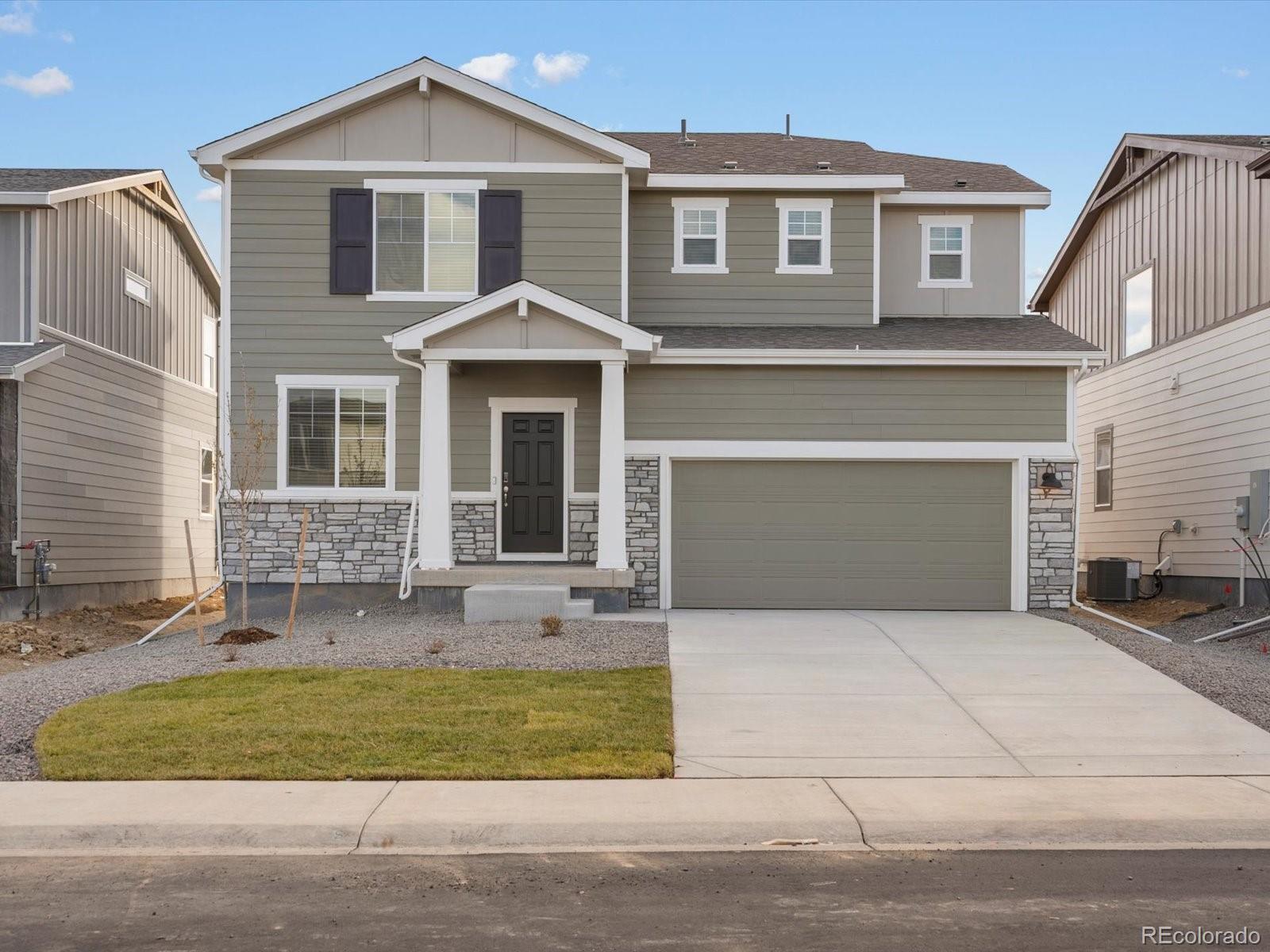 4674 Rabbitbrush Street Johnstown, CO 80534 - Photo 2 of 29 a front view of a house with a yard and garage