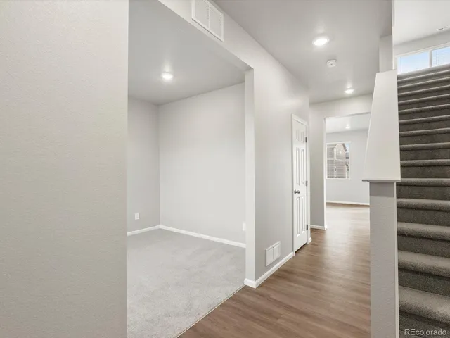 a view of a hallway with wooden floor