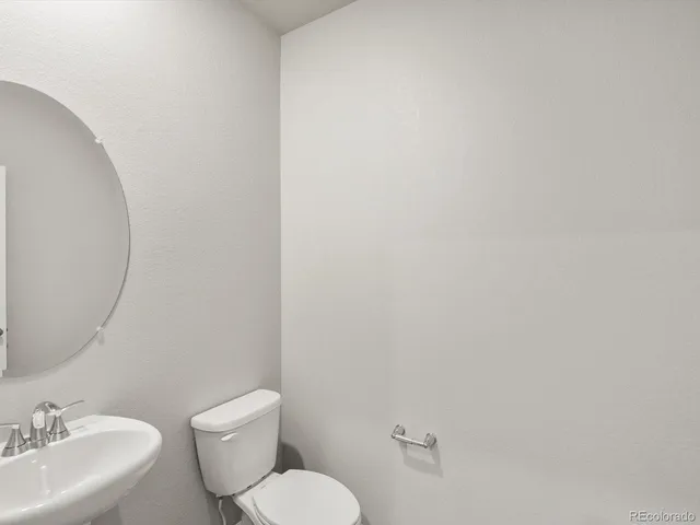 a bathroom with a toilet a sink and mirror