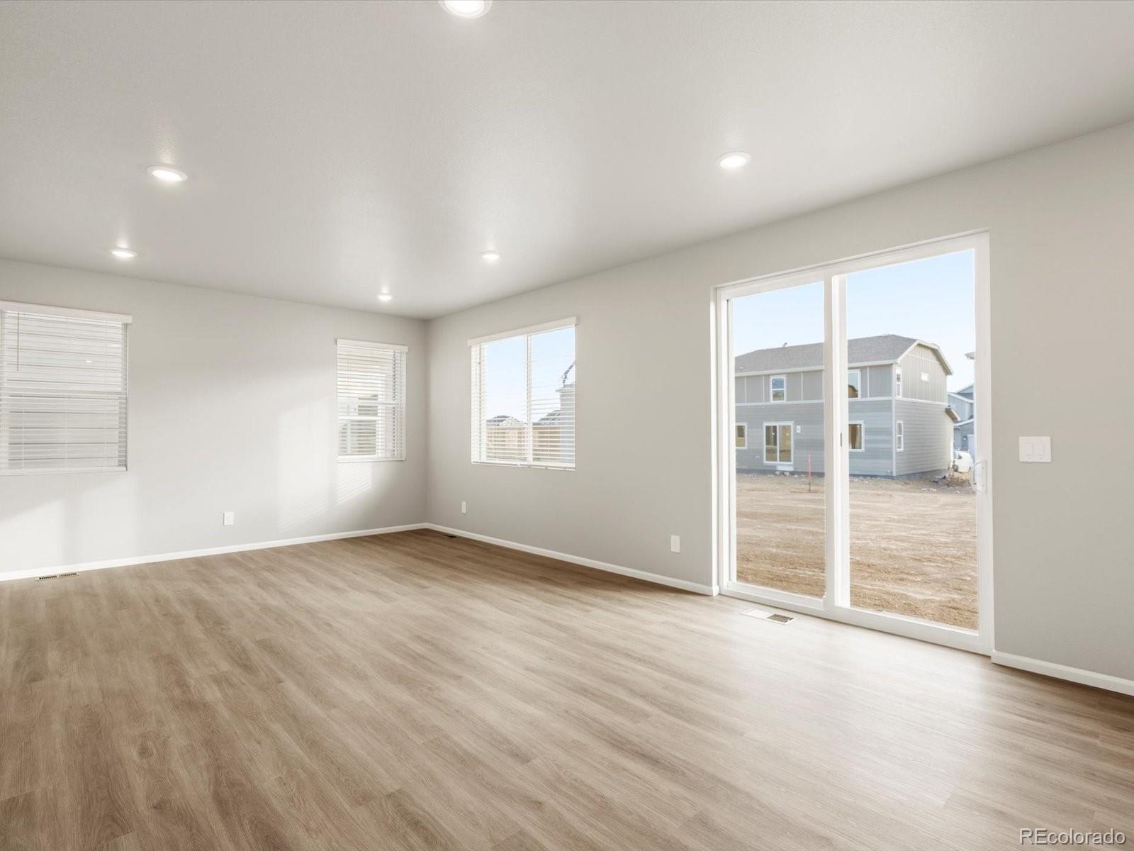 4674 Rabbitbrush Street Johnstown, CO 80534 - Photo 6 of 29 an empty room with wooden floor and windows