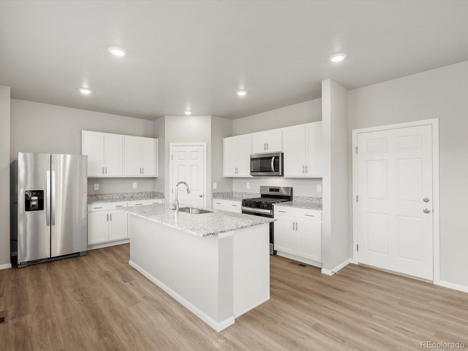 4674 Rabbitbrush Street Johnstown, CO 80534 - Photo 8 of 29 a kitchen with appliances a sink a refrigerator and cabinets