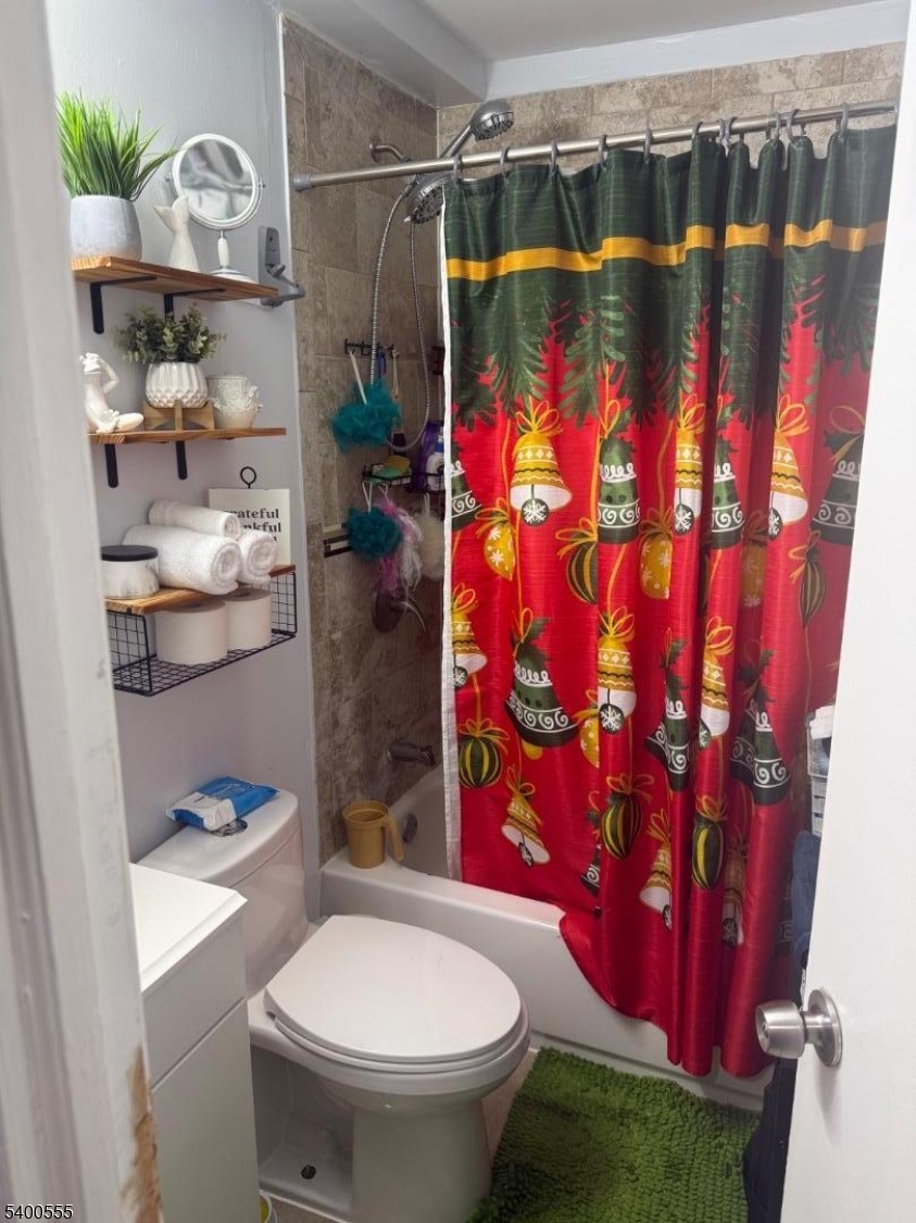 723 Thomas Street, Unit 1L Elizabeth, NJ 07202 - Photo 4 of 7 a bathroom with a toilet and shower curtain