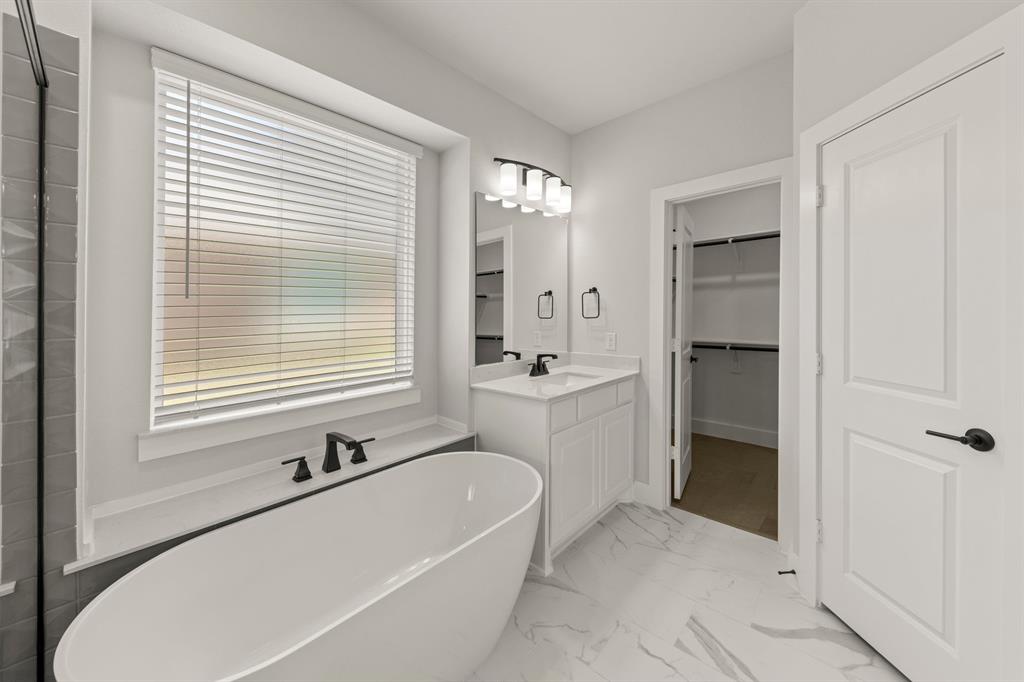 1317 Flamingo Road Forney, TX 75126 - Photo 14 of 39 a bathroom with a tub a sink a mirror and a shower