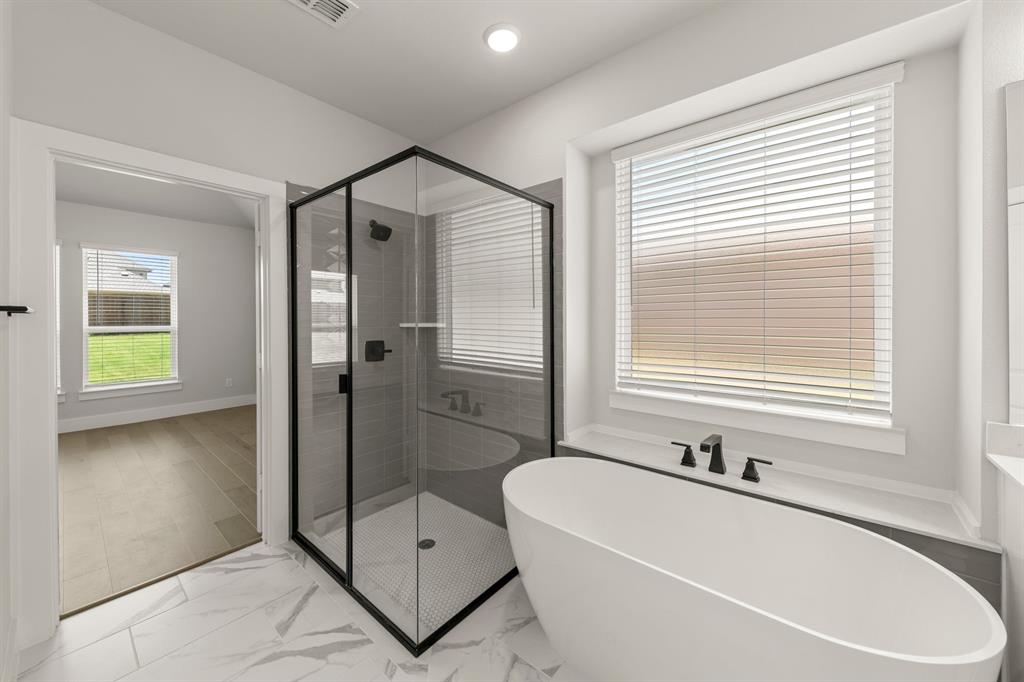 1317 Flamingo Road Forney, TX 75126 - Photo 15 of 39 a bathroom with a bathtub and a shower