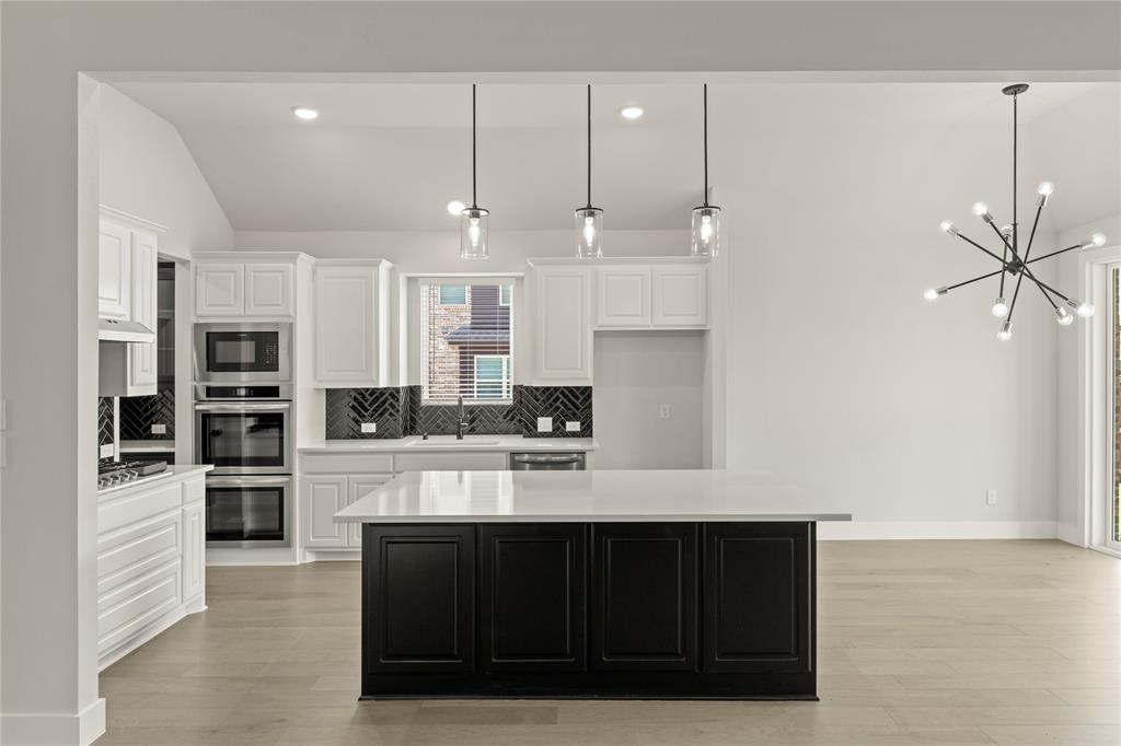 1317 Flamingo Road Forney, TX 75126 - Photo 19 of 39 a kitchen with stainless steel appliances kitchen island granite countertop a refrigerator and a stove top oven