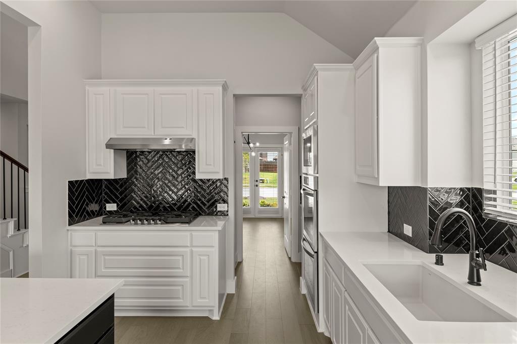 1317 Flamingo Road Forney, TX 75126 - Photo 21 of 39 a kitchen with a sink and a stove top oven