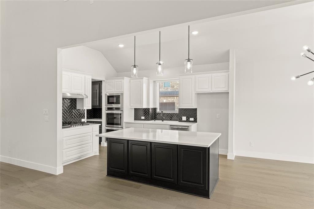 1317 Flamingo Road Forney, TX 75126 - Photo 22 of 39 a large white kitchen with a sink and dishwasher a stove with wooden floor