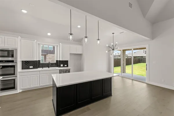 a view of an empty room with a kitchen