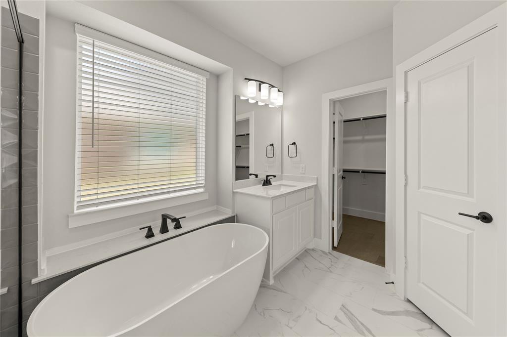 1317 Flamingo Road Forney, TX 75126 - Photo 33 of 39 a bathroom with a tub a sink a mirror and a shower