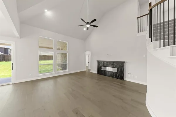 a view of a livingroom with wooden floor and a ceiling fan
