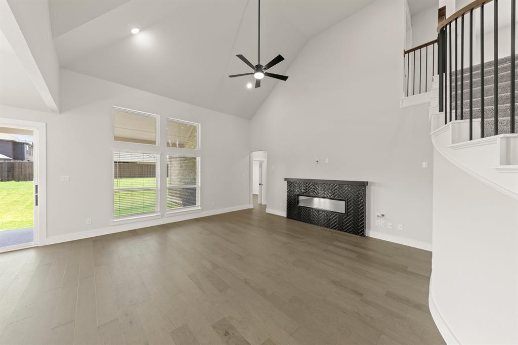 1317 Flamingo Road Forney, TX 75126 - Photo 5 of 39 an empty room with windows and fireplace