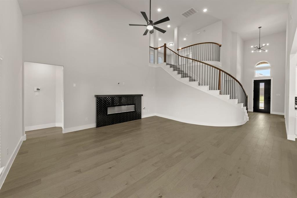 1317 Flamingo Road Forney, TX 75126 - Photo 6 of 39 a view of a livingroom with wooden floor and a ceiling fan