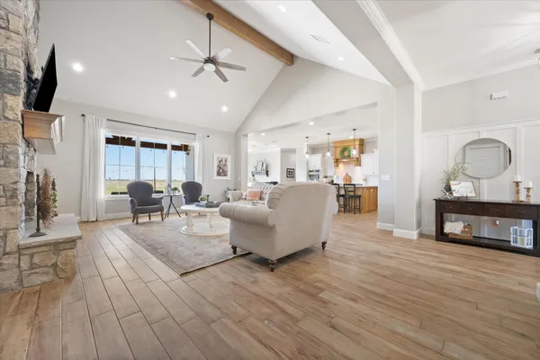 a open kitchen with stainless steel appliances granite countertop a kitchen island a stove a table and chairs